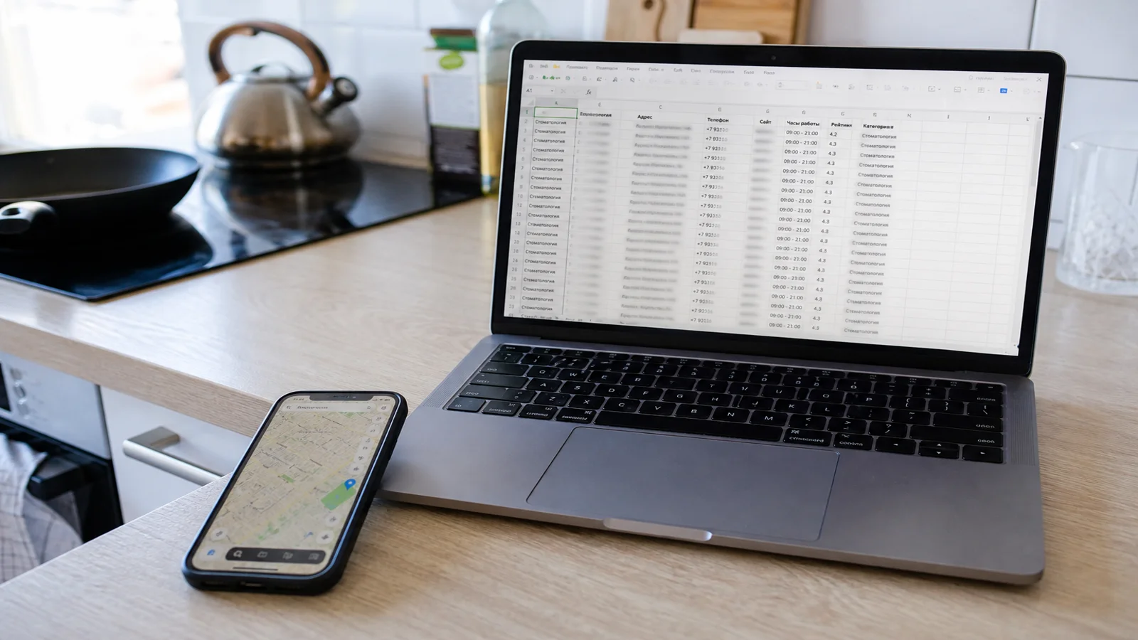 Телефон с картой 2ГИС и ноутбук с Excel на кухонном столе